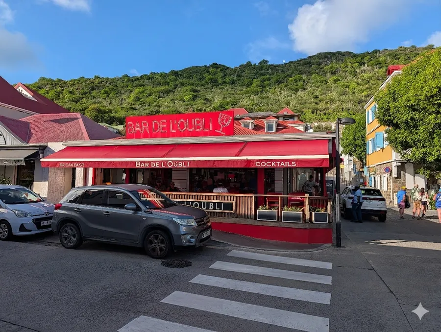 Bar de L'Oubli, a corner café in Gustavia, St. Barths — open-air terrace tables, shuttered French facades, afternoon light