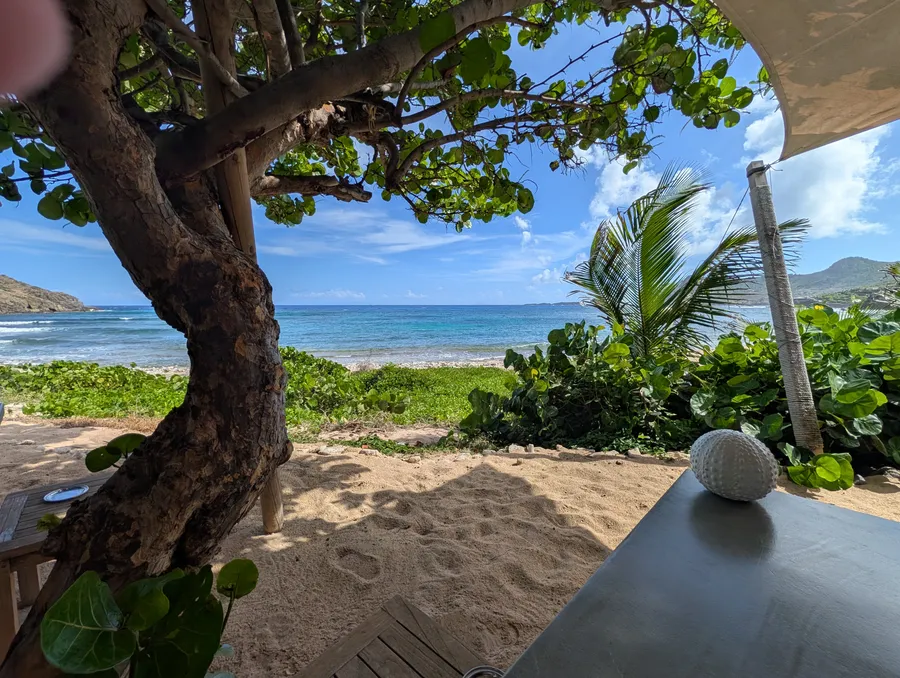 A near-empty beach on St. Barths on a weekday, pale sand and clear turquoise water stretching to the horizon
